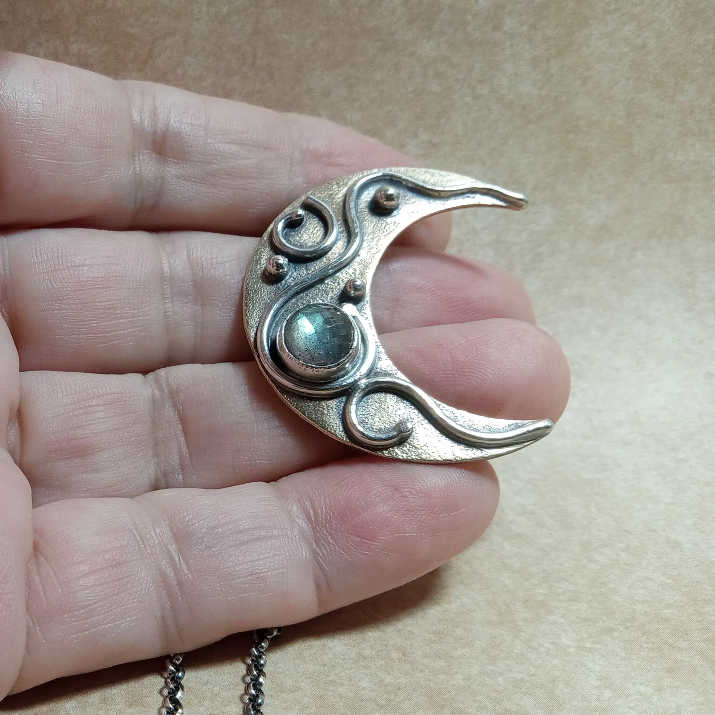 Labradorite Moon Necklace – Bronze & Sterling Silver Crescent Pendant by Mocahete, photo in hand