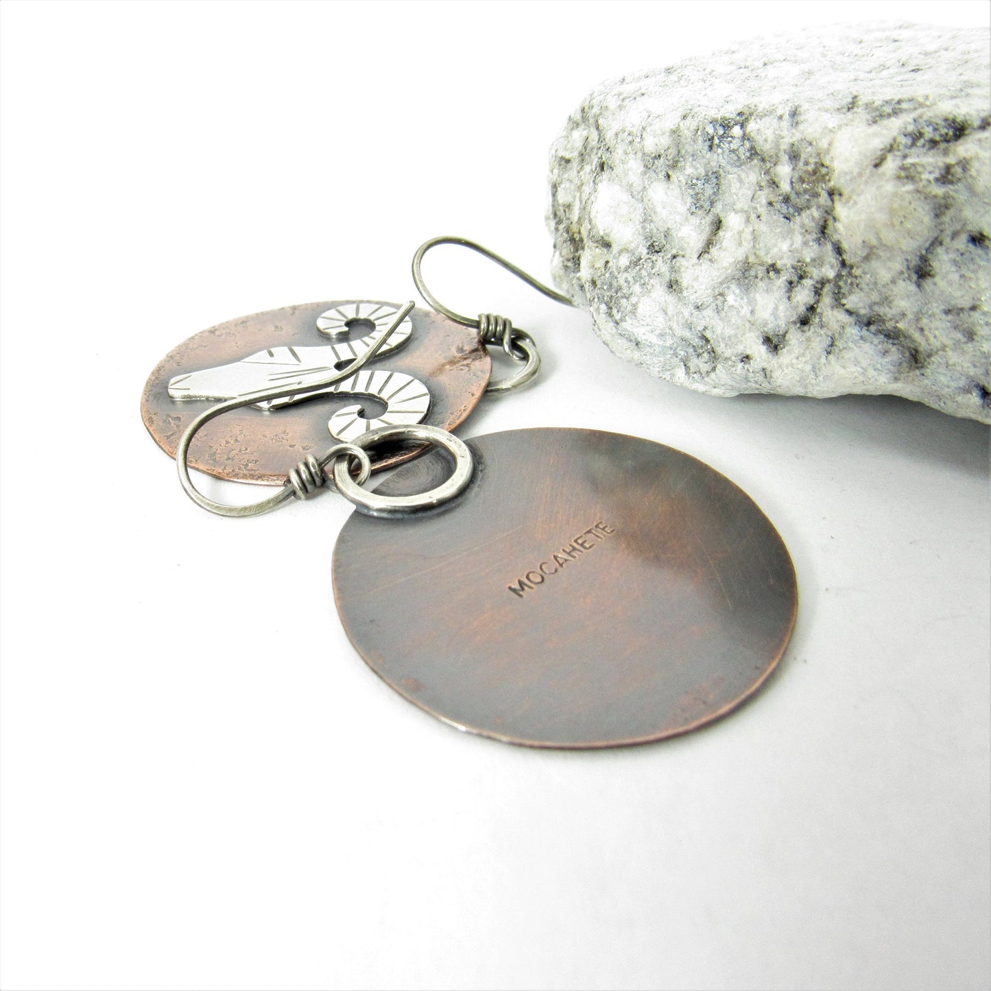 Front and back view of mixed metal rams head earrings on white background.