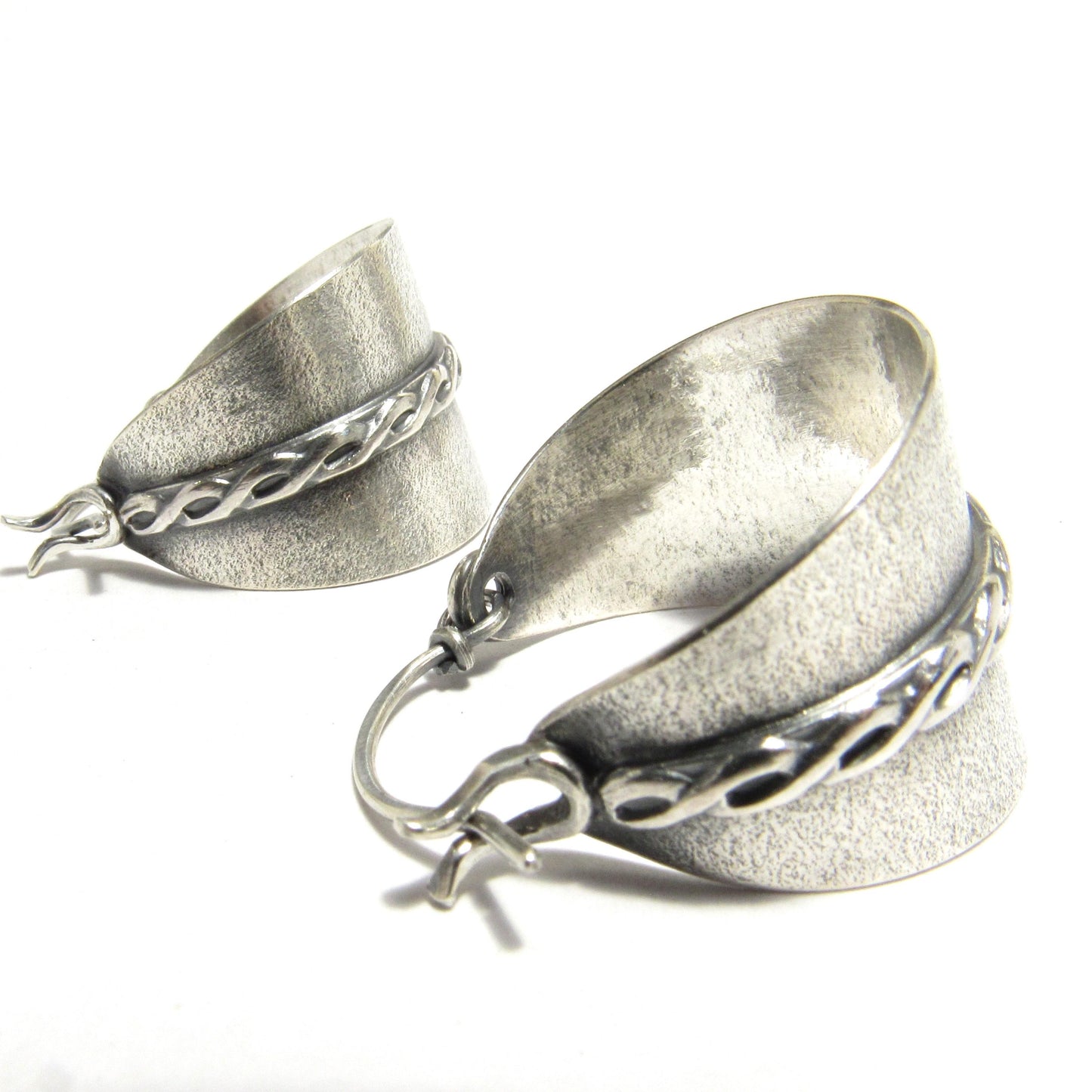 Close up of side view argentium silver stirrup or basket style hoop earrings.