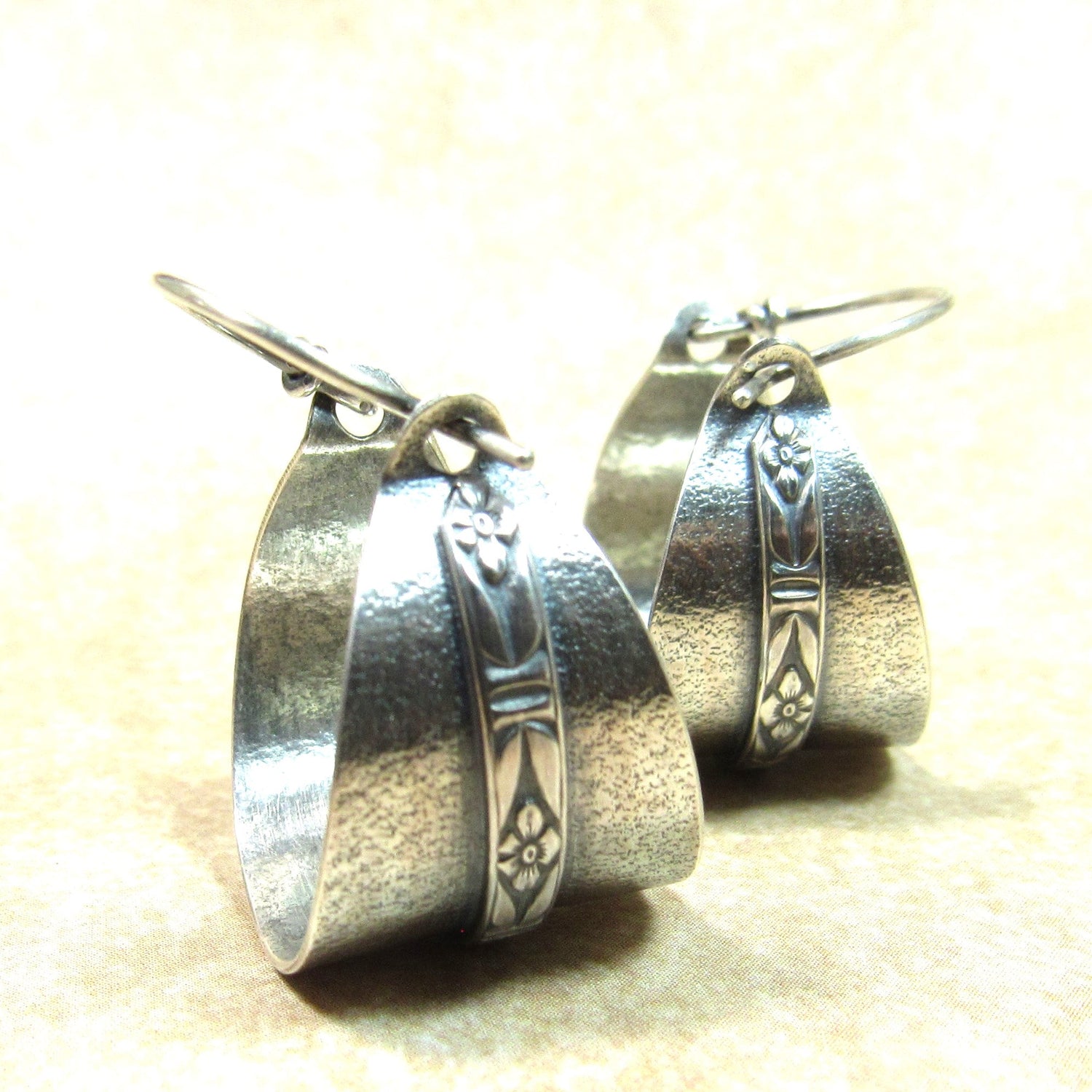Handcrafted sterling silver hoop earrings with a floral patterned band set against textured Argentium silver for timeless, everyday wear