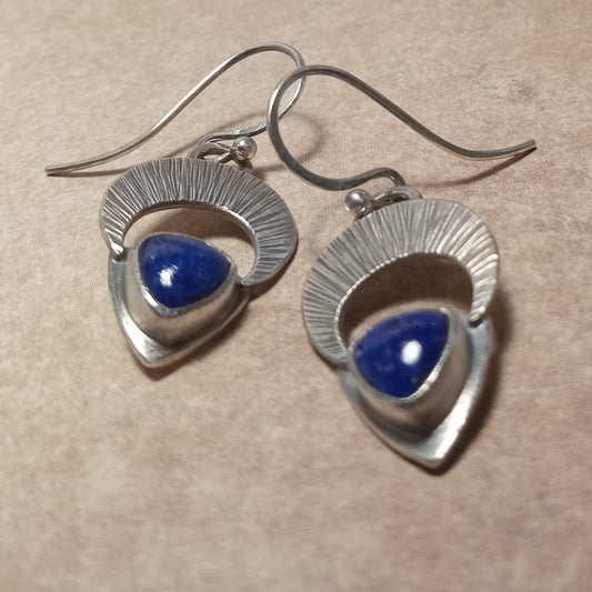 Handcrafted Argentium sterling silver earrings with textured downward-facing crescent moon and triangular lapis lazuli cabochon, lightweight dangle design by Mocahete.