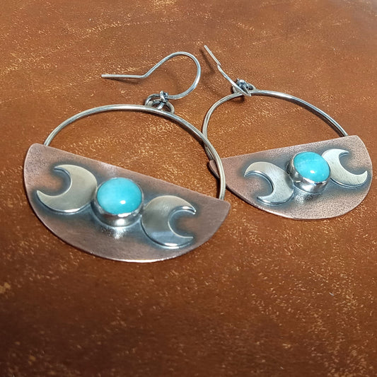  Triple Goddess earrings in copper and Argentium sterling silver with blue amazonite stones, handcrafted by Mocahete. photo on brown leather.
