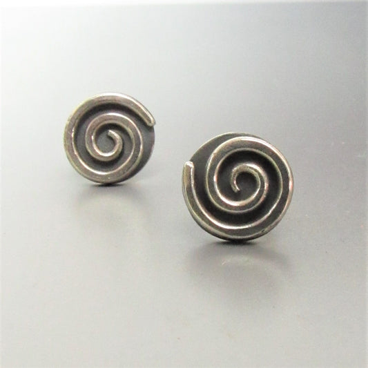 Pair of silver spiral unisex earrings on a light gray background.