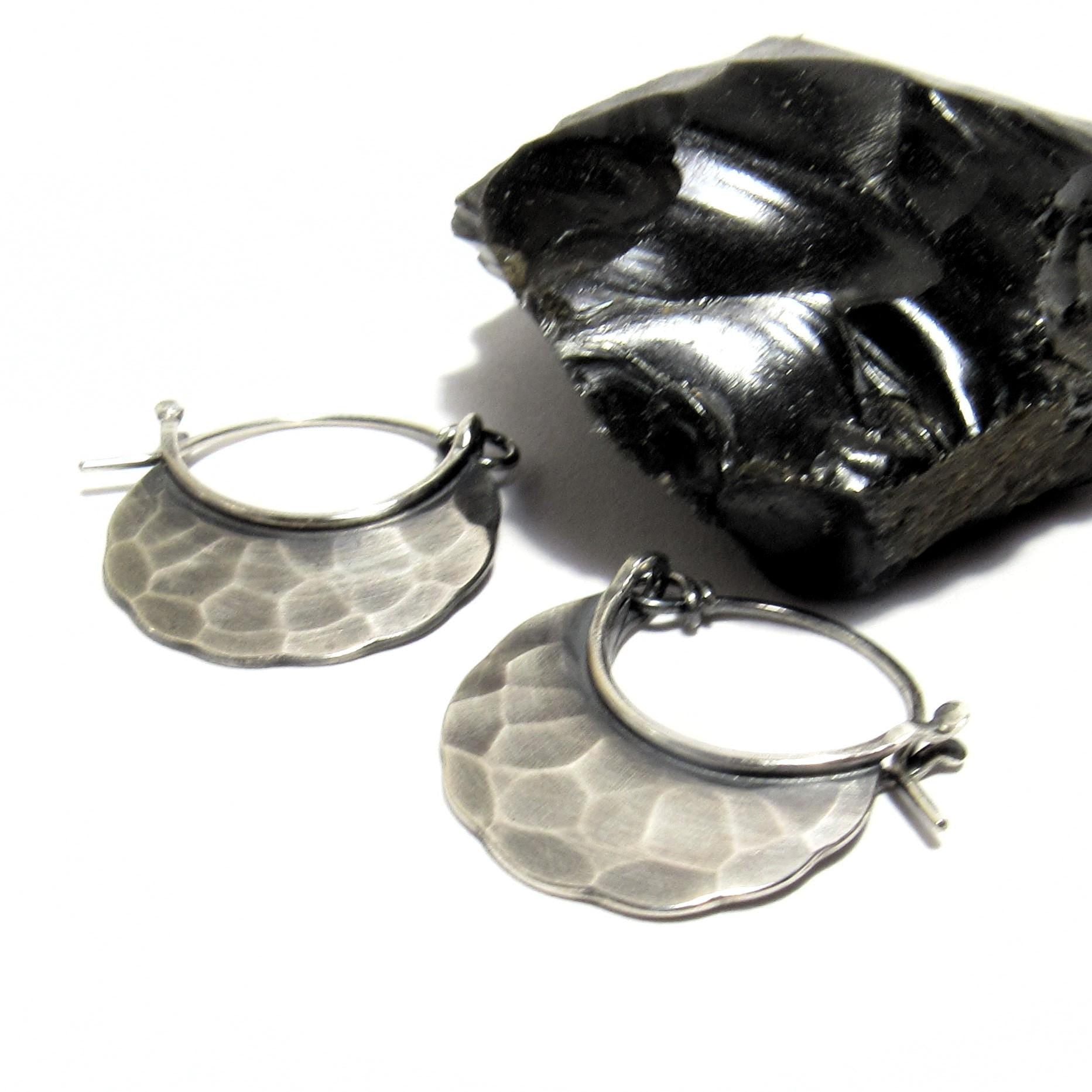 Silver hoop earrings with textured surface on a white background