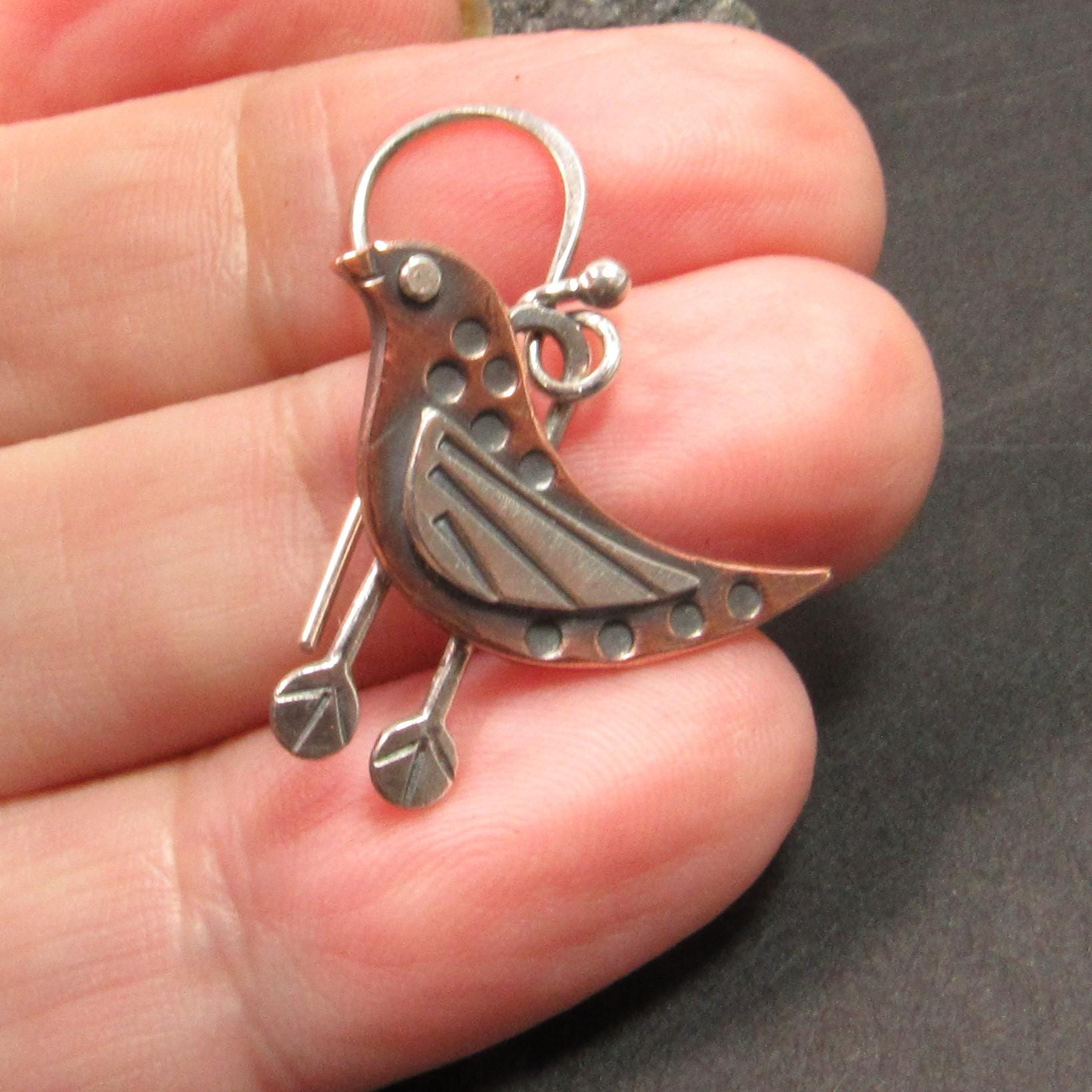 Artisan bird earrings in mixed metals with riveted accents and oxidized finish, perfect for nature lovers. Earring in hand.