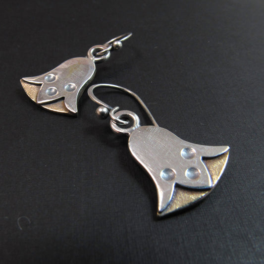 Pair of silver and bronze lotus flower earrings on a black background