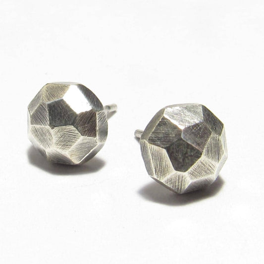 Pair of faceted silver nugget stud earrings on a white background