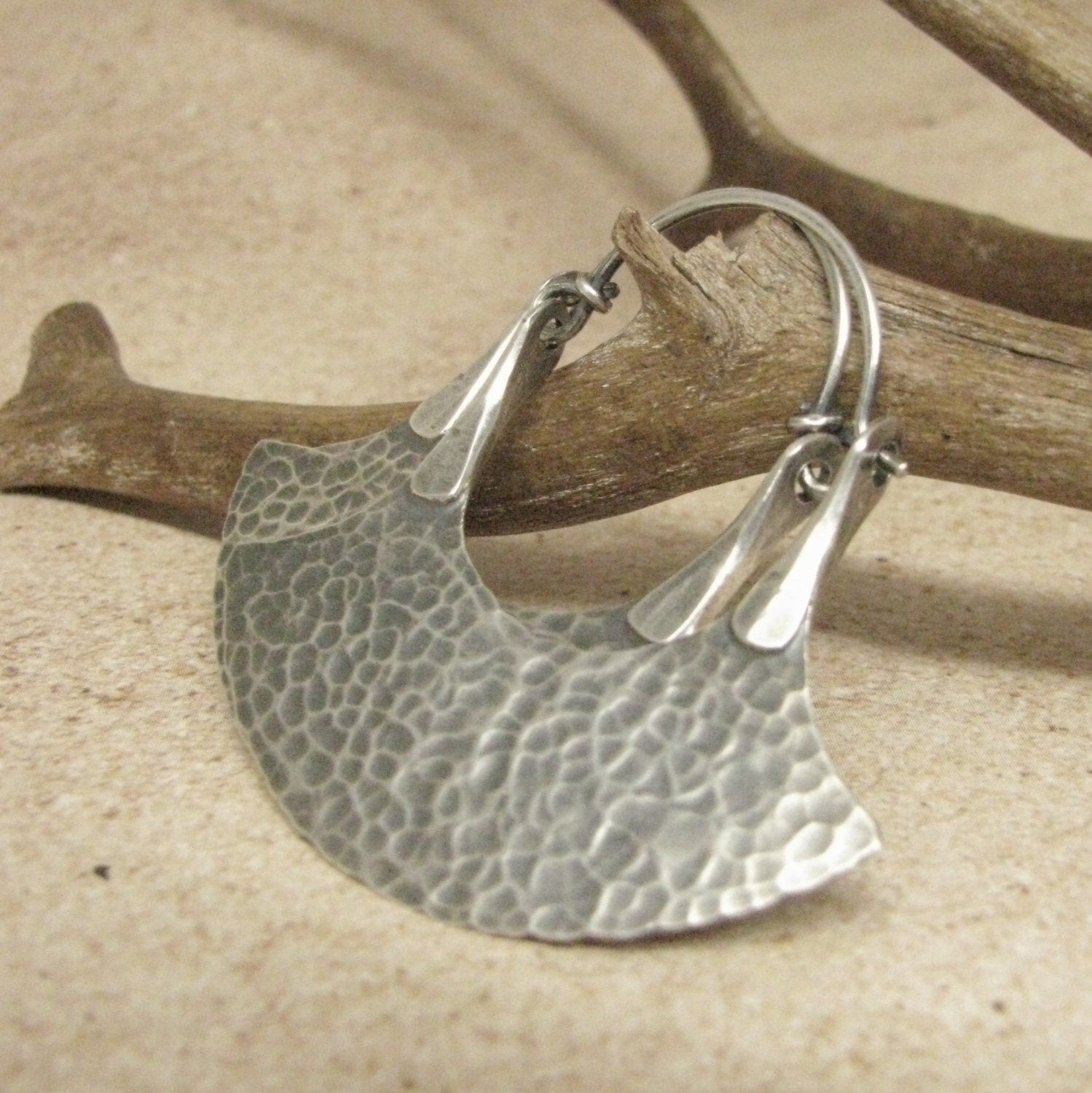 hoop earrings with unique details in sterling silver by Mocahete on twig and tile background