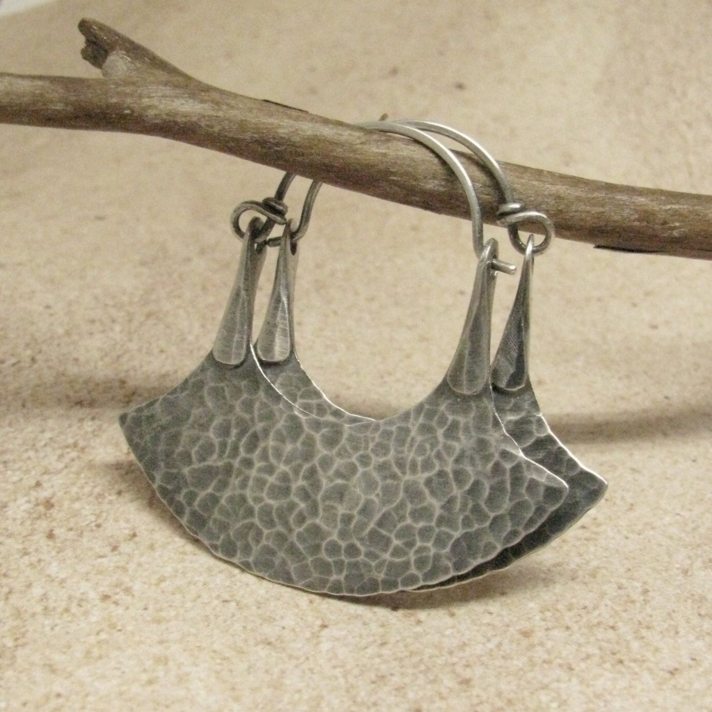 unique hoop earrings in a blade style by Mocahete on twig and tile background