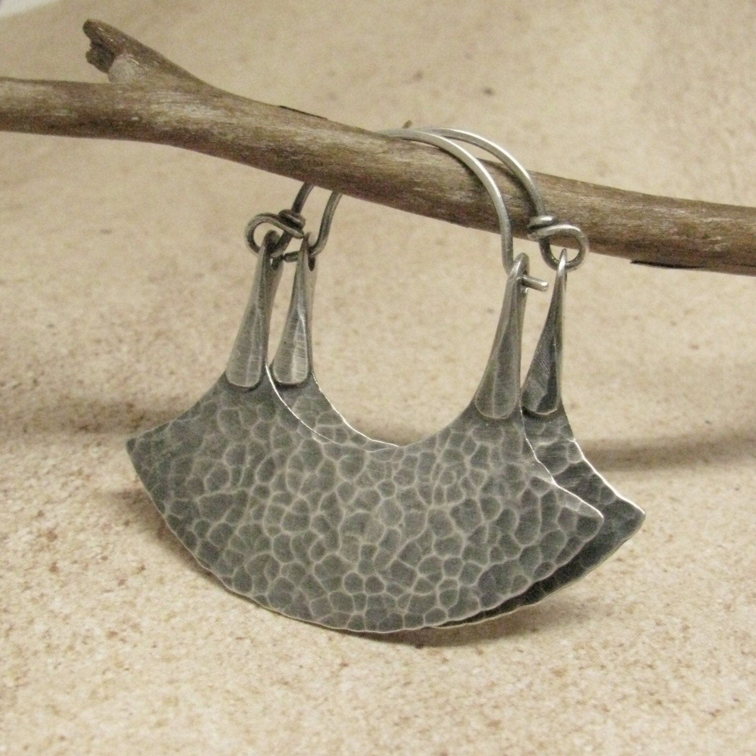 unique hoop earrings in a blade style by Mocahete on twig and tile background
