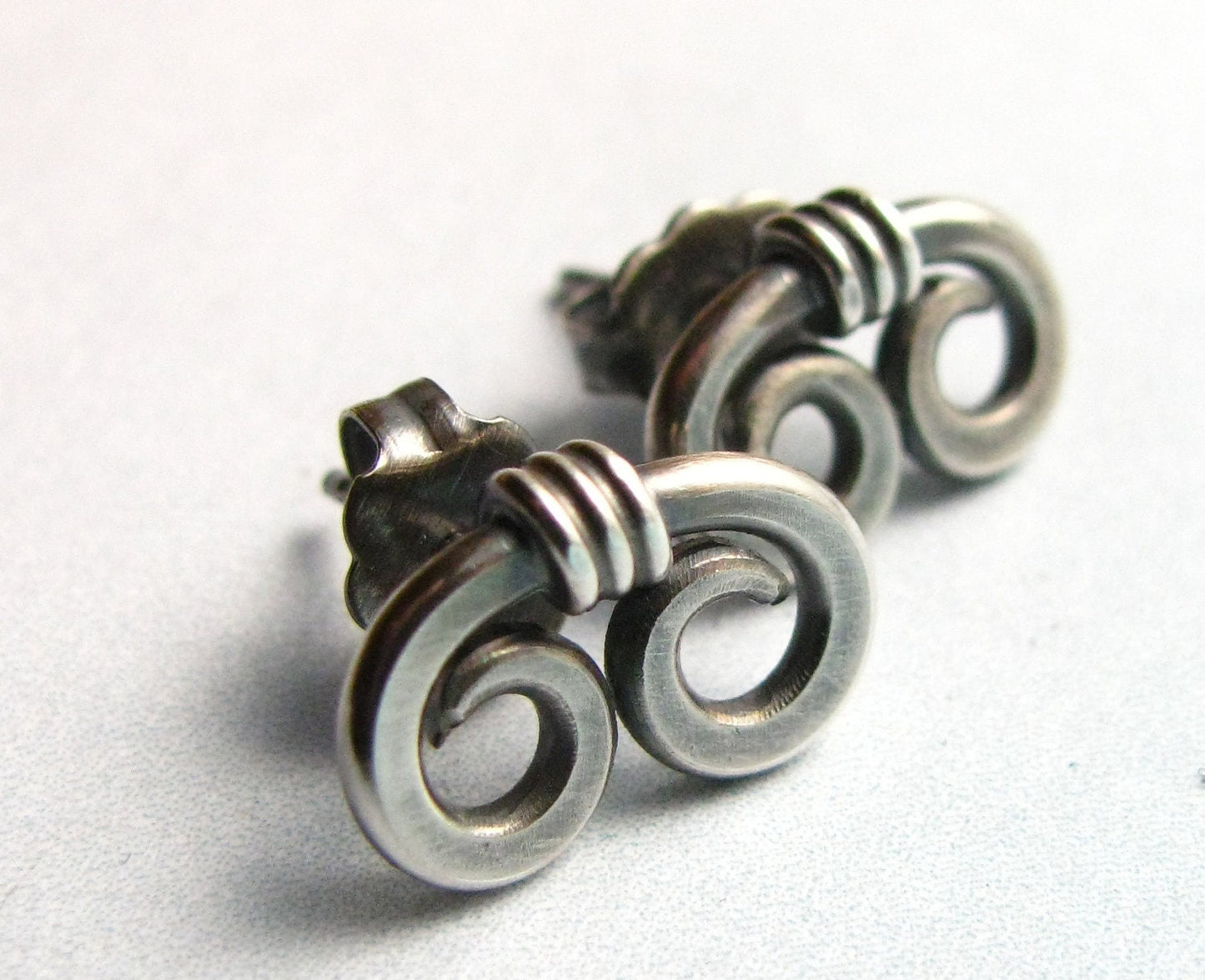 Small SS Double spiral earrings on white background.