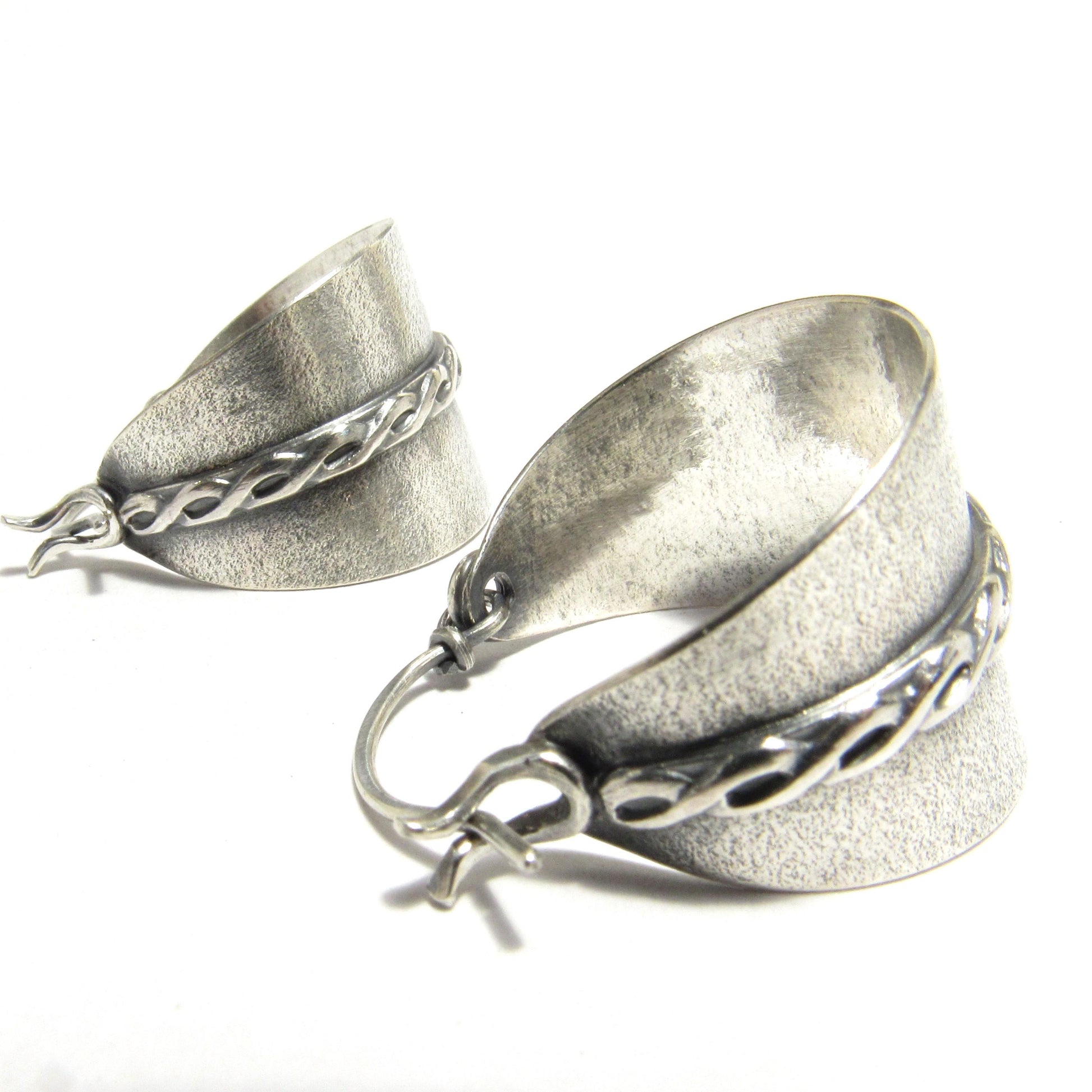 Close up of side view argentium silver stirrup or basket style hoop earrings.