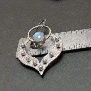 Moonstone earrings in argentium silver displayed against ruler to show width.