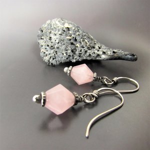 Sterling silver and faceted  pink quartz bi-cone drop earrings displayed against gray background with rock.