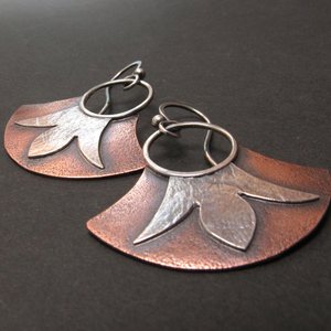 Mixed metal, copper and argentium fan earrings with floral detail. Displayed on black background.