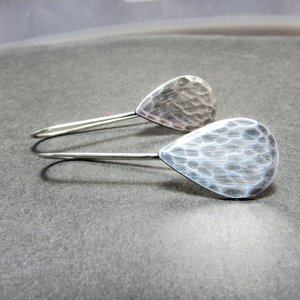 Classic hammered sterling silver teardrop earrings, 1.5" long. Displayed on grey background.