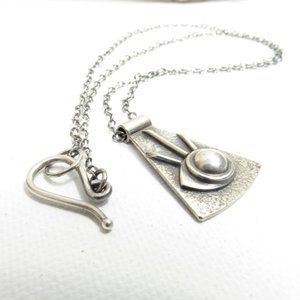 Detailed view of all seeing eye or eye of providence pendant necklace in argentium silver with hook closure and sterling silver chain. White background.