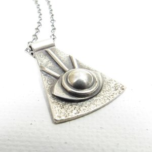Up close view of eye of providence pendant necklace in argentium silver. White background.