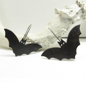 Copper and silver bat earrings. Oxidized to black. Displayed on white antler and background.