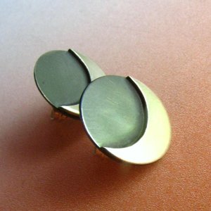 A pair of silver crescent moon earrings with a oxidized center. The earrings are made of sterling silver and have a polished finish.