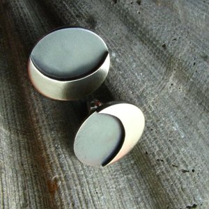 A pair of silver earrings with a crescent moon design.