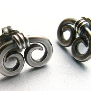 A pair of silver earrings with a spiral design. The earrings are made of sterling silver and have a post back.