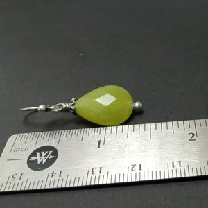 Serpentine and silver dangle earrings against ruler to show size.