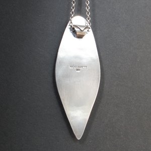 reverse side of colus fossil and turquoise pendant showing makers mark and silver purity