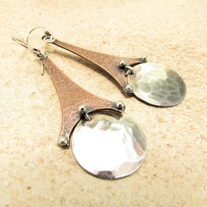 Geometric Eiffel tower earrings, mixed metals, copper, silver. Displayed on neutral background.