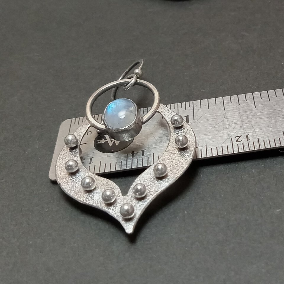 Moonstone earrings in argentium silver displayed against ruler to show width.