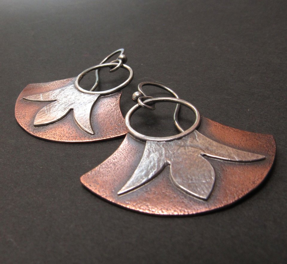 Mixed metal, copper and argentium fan earrings with floral detail. Displayed on black background.