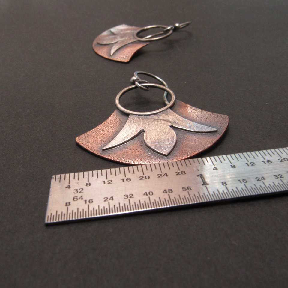 Fan shape mixed metal earrings in copper and argentium silver. Floral detail. Shown against ruler to show size.