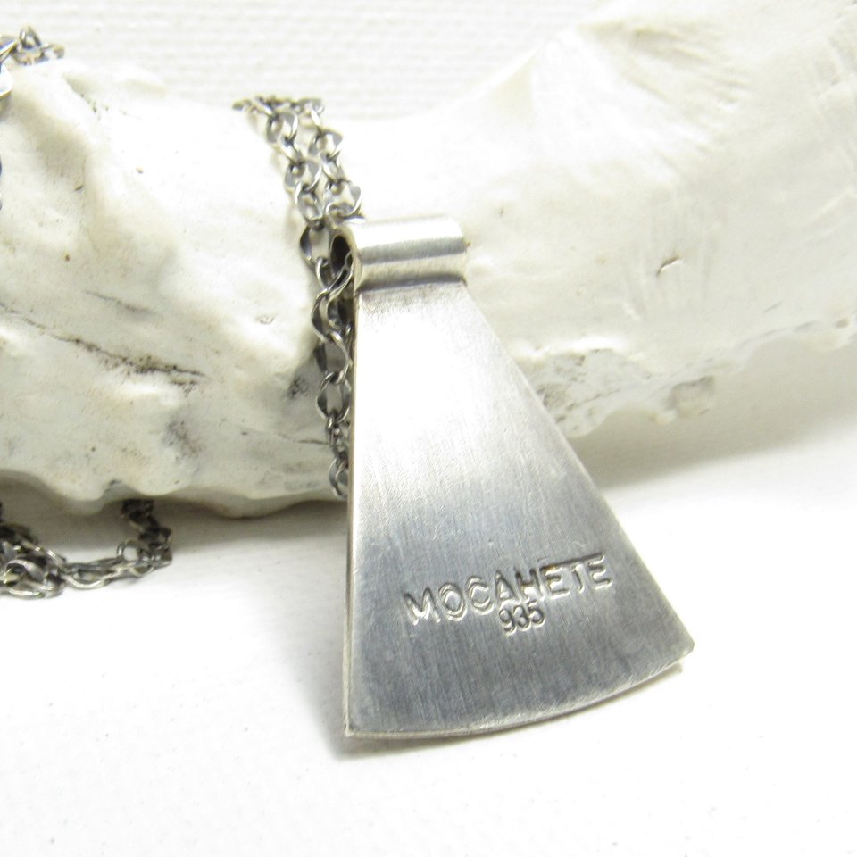 Reverse side showing makers mark and silver purity of Eye of providence necklace in argentium sterling silver with 18" chain. Displayed on white background with antler.