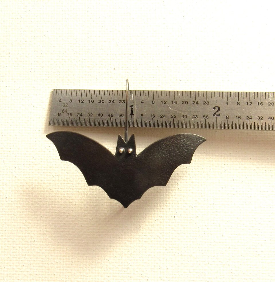 Mixed metal copper and silver bat earrings. Displayed against ruler to show almost 2" wide.