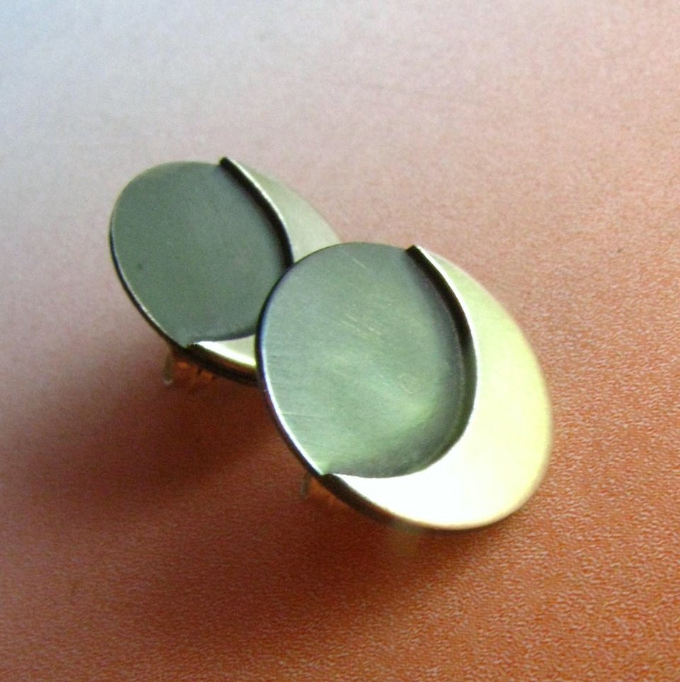 A pair of silver crescent moon earrings with a oxidized center. The earrings are made of sterling silver and have a polished finish.