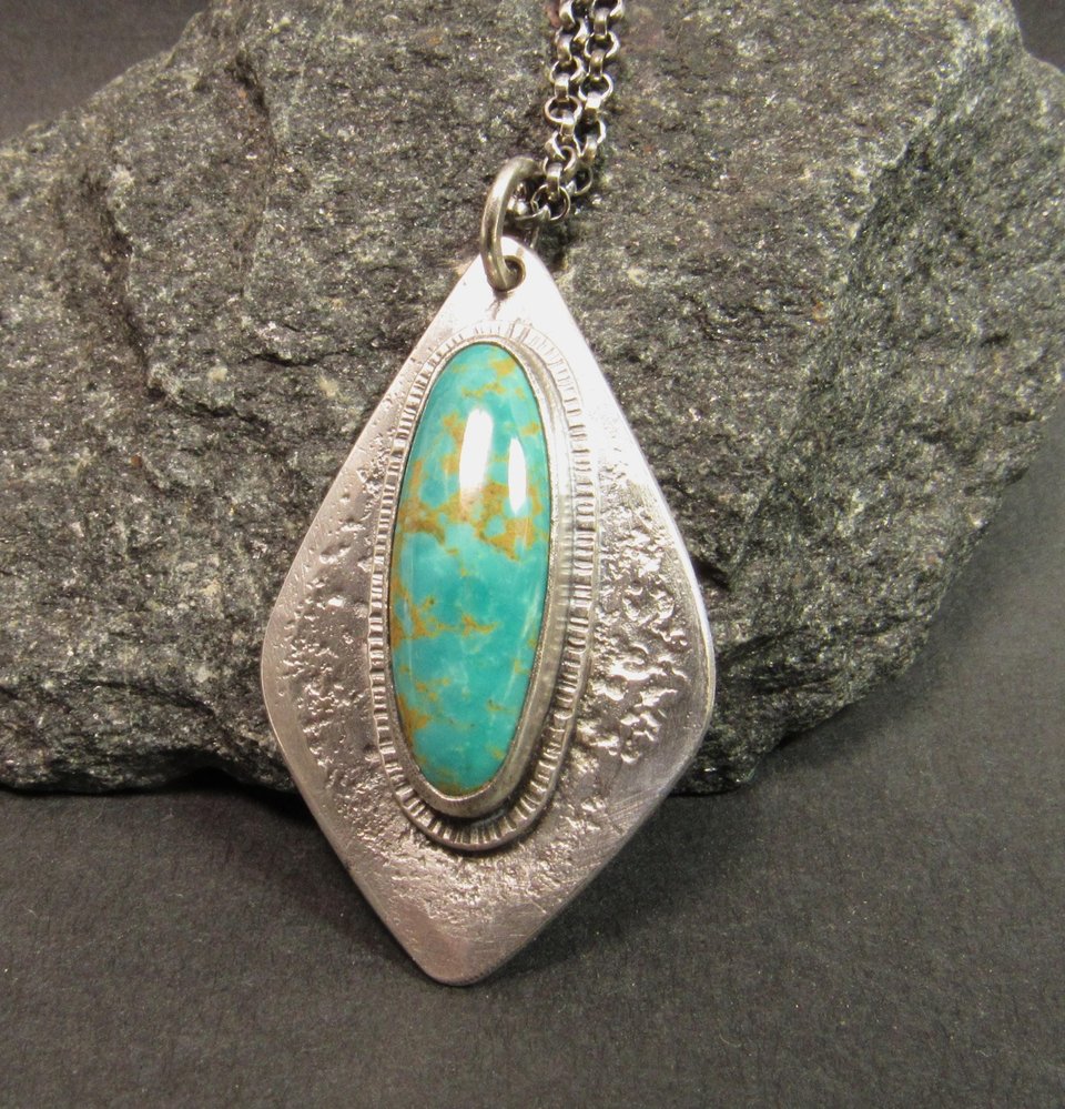 Stunning turquoise from the number 8 mine is set on a textured argentium sterling silver backplate in an organic geometric shape, Pendant is 1.75 inch long, a touch over 1 inch wide at widest point. The chain is sterling silver and measures 20 inch