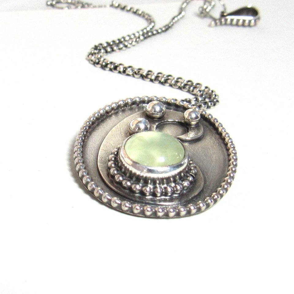 Argentium silver and green prehnite paisley necklace on white background with chain and clasp in the background.