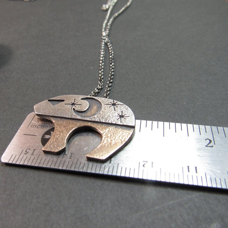 Ursa Major bear pendant against ruler to show size.
