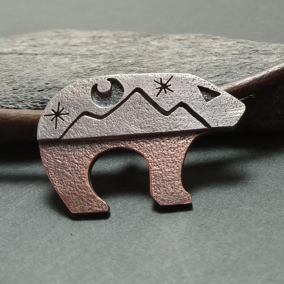 Mixed metal, copper and silver bear pendant on leather cord against rock.Moon and star cutouts on top half of bear. 18-22 cord, Bear is 1.25" long and .75" tall.