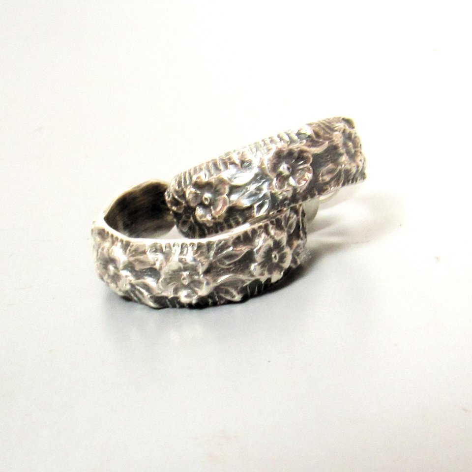 Floral pattern sterling silver post back hoops on light grey background.