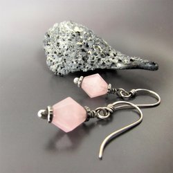 Sterling silver and faceted  pink quartz bi-cone drop earrings displayed against gray background with rock.