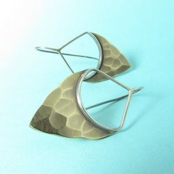 Striking, handcrafted sterling silver and bronze earrings have a two tone geometric design. Hammered for a knapped arrowhead appearance , oxidized and polished. Sterling silver fixed ear wire, 1-5/8" tall and 7/8" wide.  Displayed against blue background.