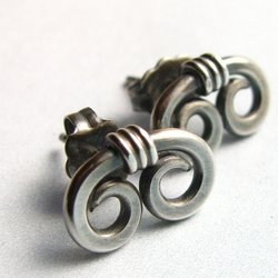A pair of silver earrings with a unique, twisted design. Each earring features two connected loops, creating a swirling, organic spiral shape.