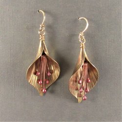 Handcrafted, unique mixed metal lily flower earrings are lovely with the warm metals of gold, bronze and copper. Reddened copper stamens tinkle gently.2 and 1/8" or 6cm long and .75"  or 1.9cm wide at widest point.