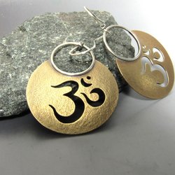 Golden bronze and sterling silver om or aum earrings. Sand textured bronze disks with  om cut out and sterling silver ear wires. 1 and 7/8 inch tall x 1.25 inch wide. perfect for yoga enthusiast.