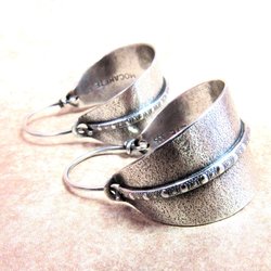 Sterling silver hoop earrings basket style fancied up with a strip of patterned  silver wire against textured argentium silver. A perfect sterling silver hoop earring for every occasion!  Oxidized, polished, finished with sterling ear wires. 1.25" or 3.1cm tall,  7/8" or 2.22cm wide. Displayed on neutral background.